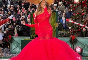 Mariah Carey de vestido vermelho segurando sombrinha e microfone - metrópoles